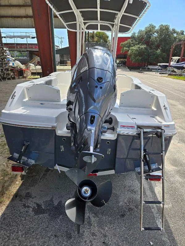 Slide: The Image of 2025 Robalo R180 Center Console boat with outboard motor and ladder, parked outdoors. - 3