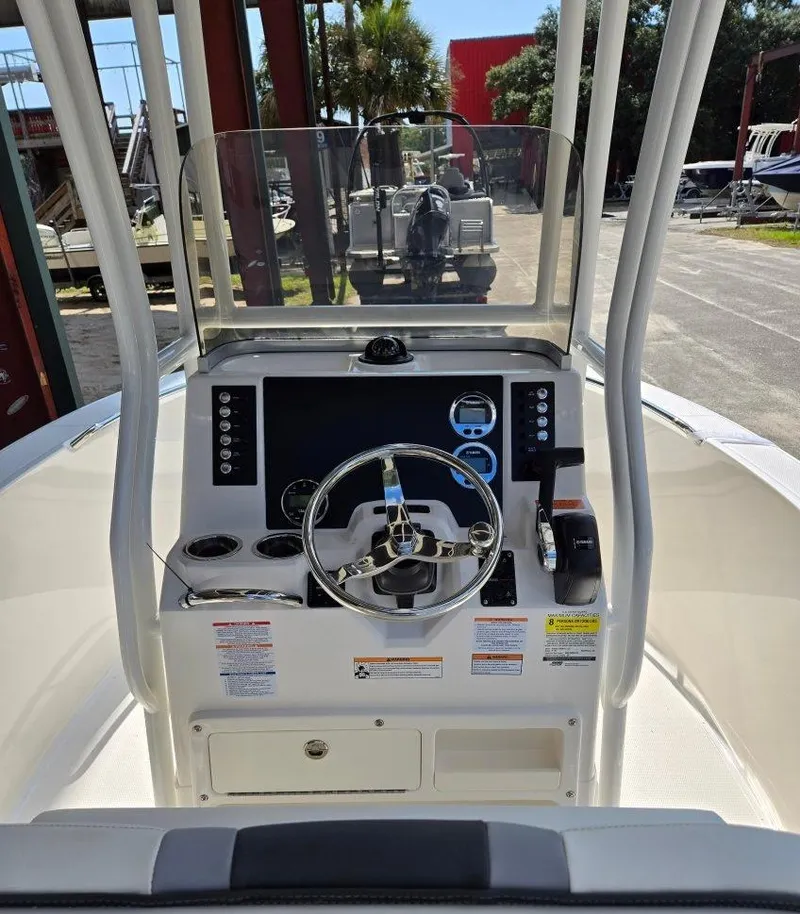 Slide: The Image of 2025 Robalo R180 Center Console boat dashboard with steering wheel and controls. - 7