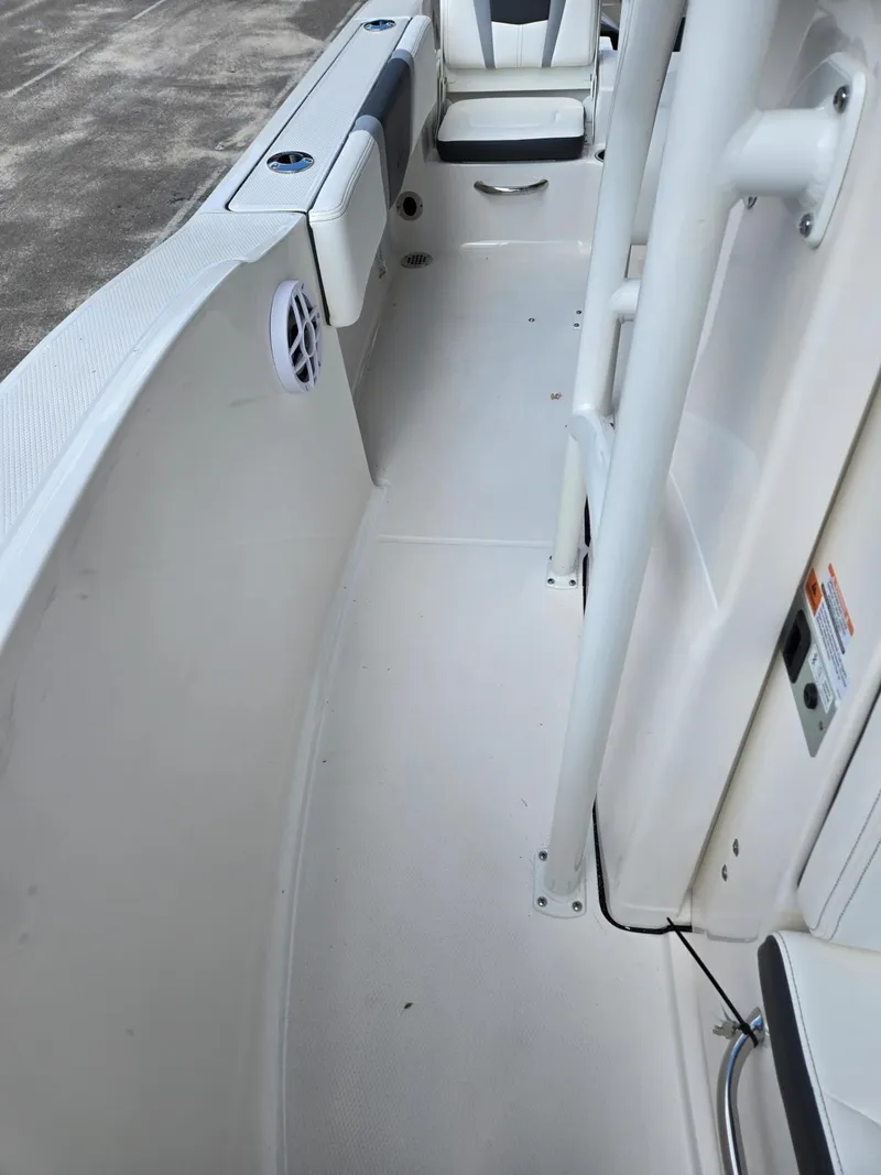 Slide: The Image of 2025 Robalo R180 Center Console boat interior, featuring sleek white design and seating area. - 9
