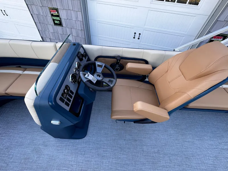 Slide: The Image of 2025 Avalon 2385 Aura Quad Lounge boat interior with tan seating and modern helm. - 15