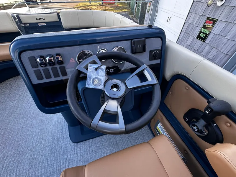 Slide: The Image of 2025 Avalon 2385 Aura Quad Lounge boat dashboard with steering wheel and controls. - 16