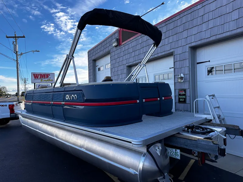 Slide: The Image of 2025 Avalon 2385 Aura Quad Lounge pontoon boat parked outside a garage. - 4