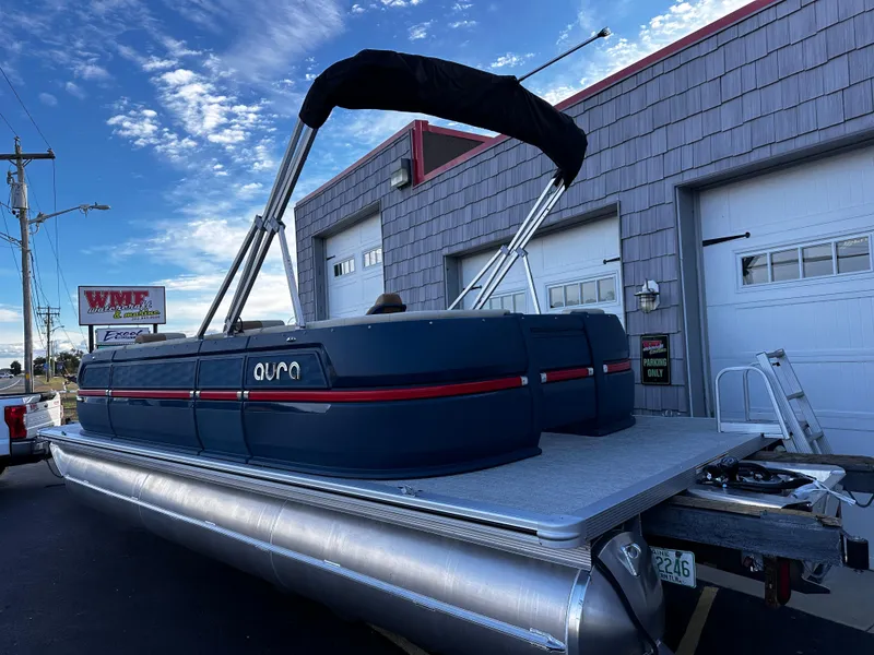 Slide: The Image of 2025 Avalon 2385 Aura Quad Lounge pontoon boat parked outside a garage. - 5