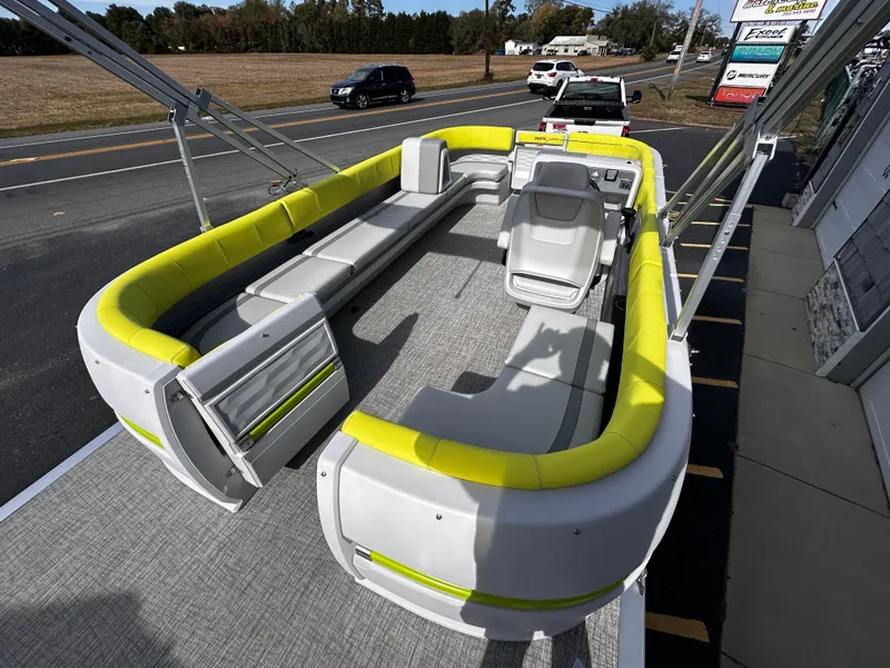 Slide: The Image of 2025 Avalon 2185 Aura Quad Lounge boat with bright yellow seating, parked on a trailer. - 11