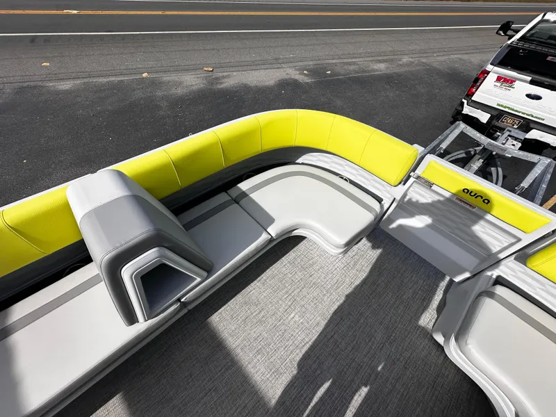 Slide: The Image of 2025 Avalon 2185 Aura Quad Lounge boat with yellow and gray seating, parked on a trailer. - 15
