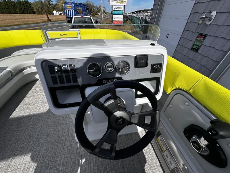 Slide: The Image of Steering console of 2025 Avalon 2185 Aura Quad Lounge boat with yellow seating. - 21