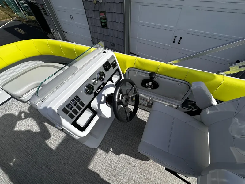 Slide: The Image of 2025 Avalon 2185 Aura Quad Lounge boat interior with modern dashboard and seating. - 26