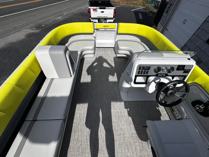 Slide: The Image of 2025 Avalon 2185 Aura Quad Lounge boat interior with yellow seating and modern dashboard. - 27