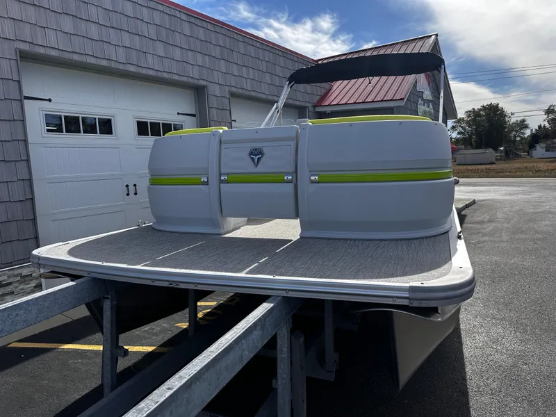 Slide: The Image of 2025 Avalon 2185 Aura Quad Lounge Twin Toon pontoon boat on trailer, parked outdoors. - 4