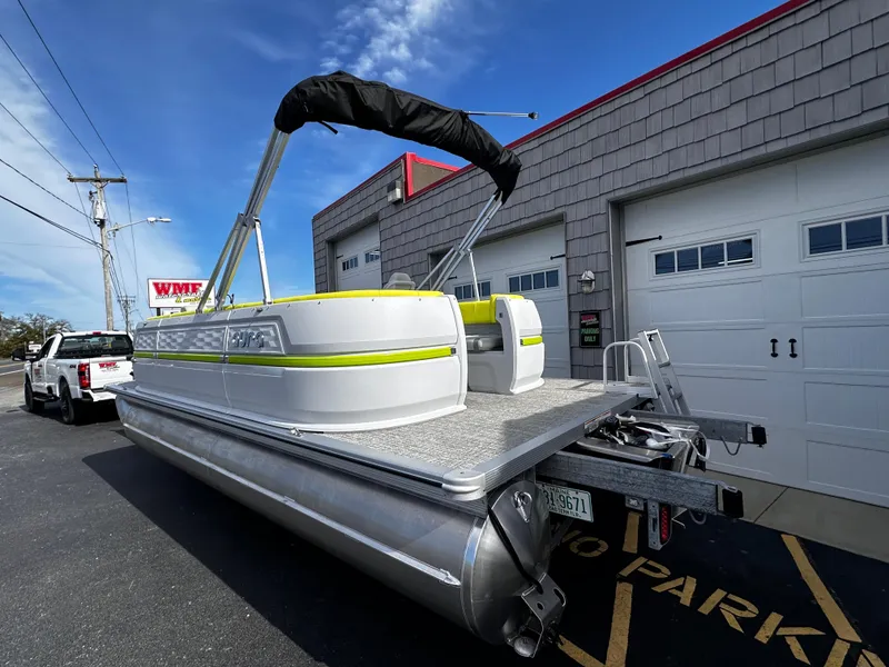 Slide: The Image of 2025 Avalon 2185 Aura Quad Lounge pontoon boat parked outside a garage. - 5