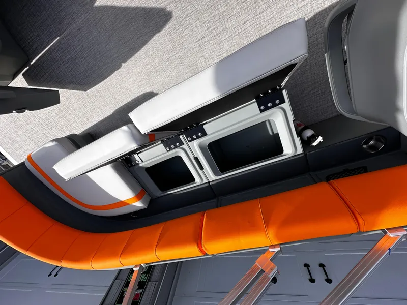 Slide: The Image of 2025 Avalon 2385 Aura Quad Lounge interior with orange and gray seating, open storage compartments. - 19