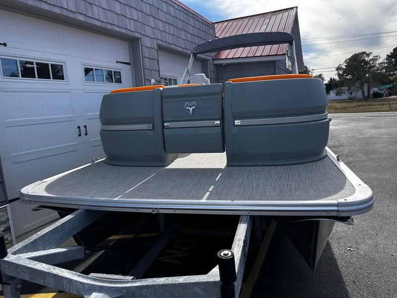 Slide: The Image of 2025 Avalon 2385 Aura Quad Lounge Twin Toon boat on trailer, parked outside garage. - 3