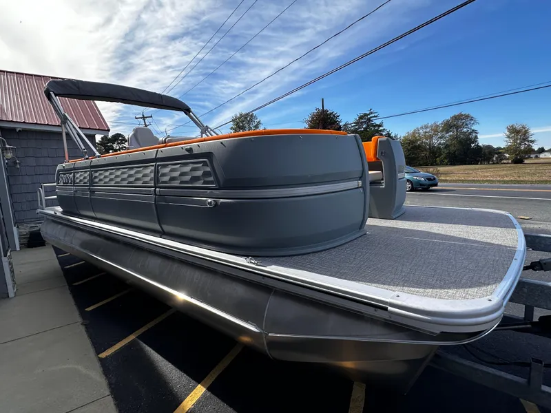 Slide: The Image of 2025 Avalon 2385 Aura Quad Lounge pontoon boat, sleek design, parked outdoors. - 7