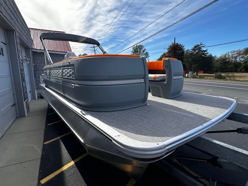 Slide: The Image of 2025 Avalon 2385 Aura Quad Lounge pontoon boat with sleek gray design and orange seating. - 8