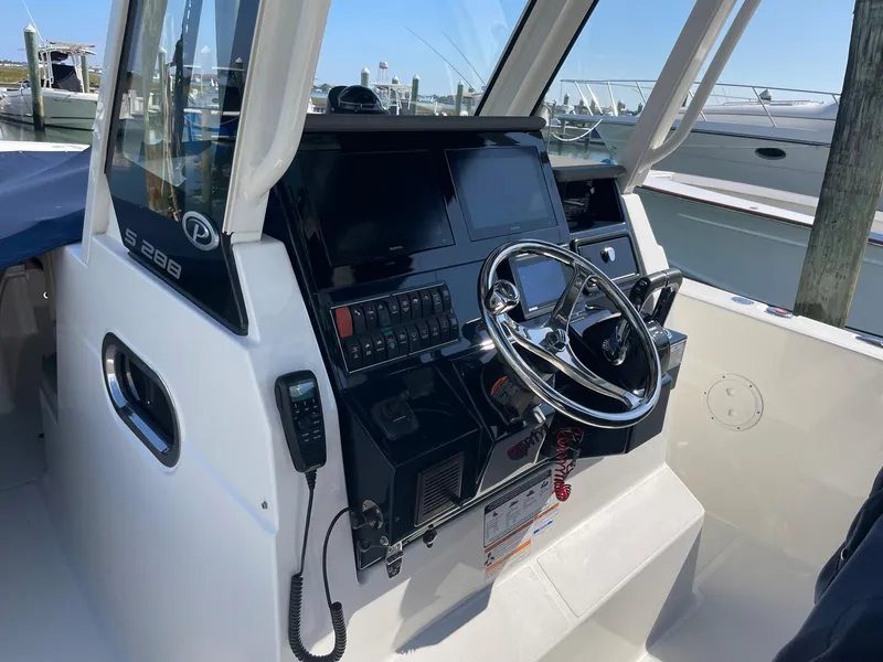 Slide: The Image of Cockpit of 2020 Pursuit S 288 boat with steering wheel and control panel. - 12