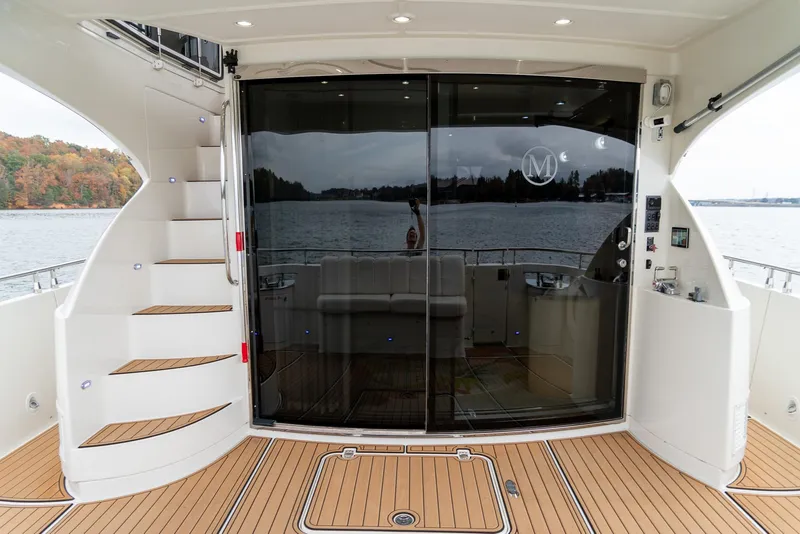 Slide: The Image of 2007 Marquis 59 Markham Edition yacht with sleek deck and glass doors on a serene lake. - 13