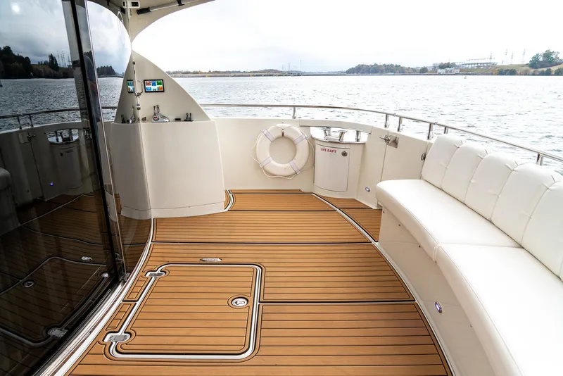 Slide: The Image of Luxurious 2007 Marquis 59 Markham Edition yacht deck with elegant seating and scenic water view. - 18