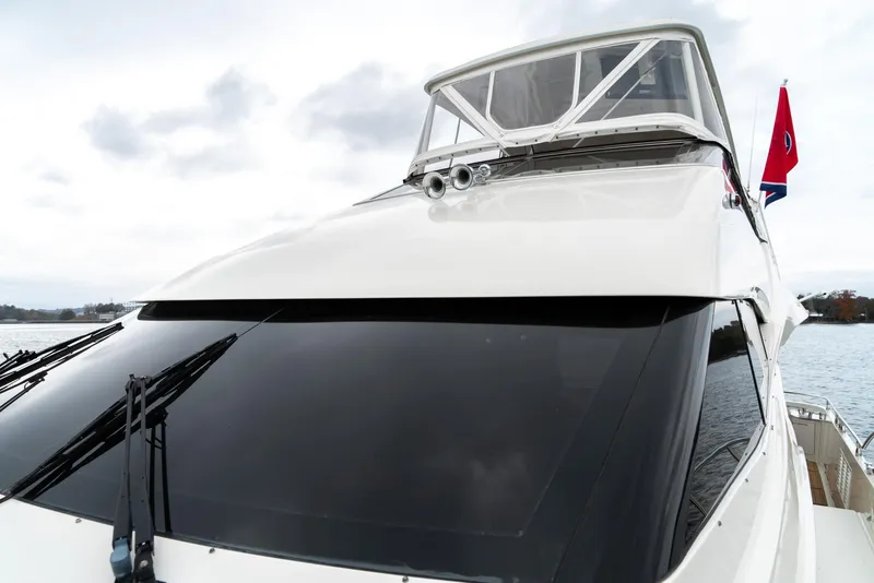 Slide: The Image of 2007 Marquis 59 Markham Edition yacht with sleek design and tinted windows on water. - 30