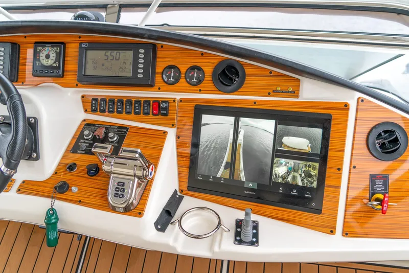 Slide: The Image of 2007 Marquis 59 Markham Edition yacht dashboard with wood paneling and navigation controls. - 39