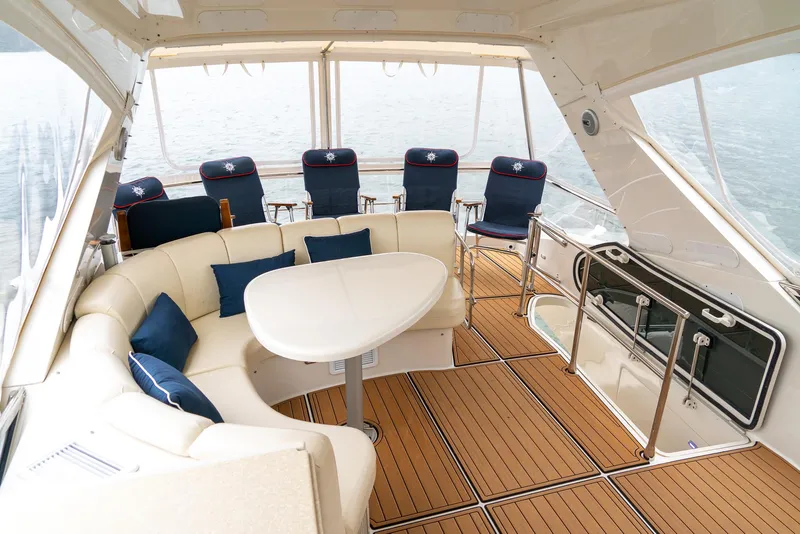 Slide: The Image of Luxurious 2007 Marquis 59 yacht interior with elegant seating and table on teak deck. - 45