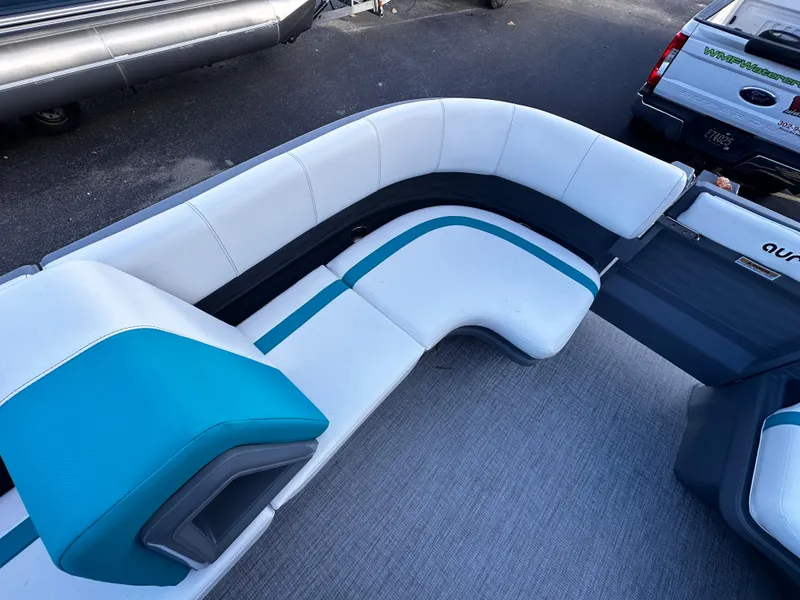 Slide: The Image of 2025 Avalon 2385 Aura Quad Lounge interior with white and teal seating. - 11