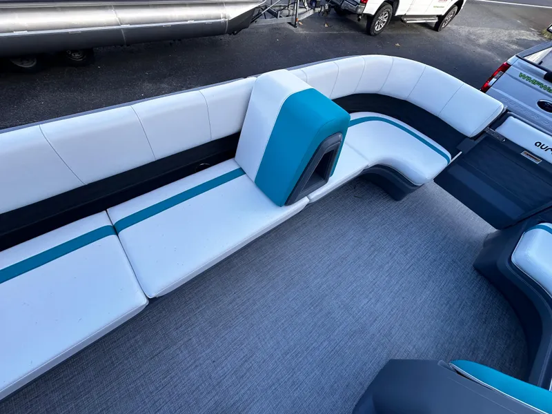 Slide: The Image of 2025 Avalon 2385 Aura Quad Lounge interior with sleek white and teal seating. - 15