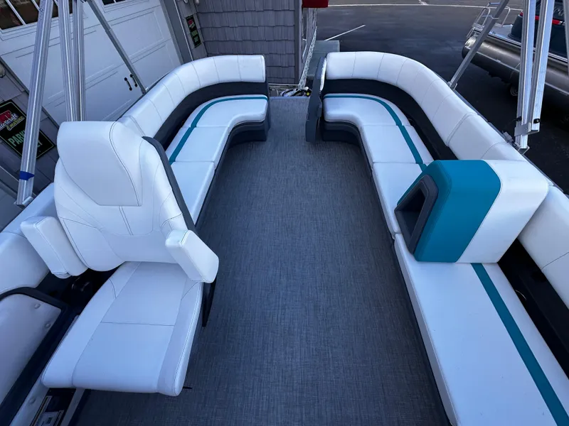 Slide: The Image of 2025 Avalon 2385 Aura Quad Lounge interior with white and teal seating. - 17