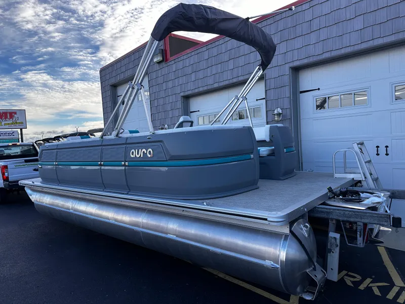 Slide: The Image of 2025 Avalon 2385 Aura Quad Lounge pontoon boat, parked outside a building. - 4