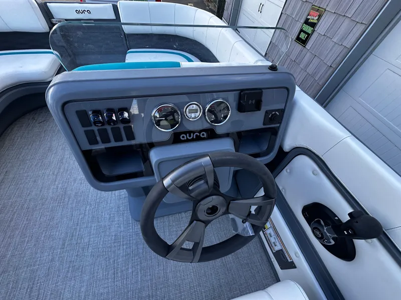 Slide: The Image of 2025 Avalon 2385 Aura Quad Lounge boat dashboard with steering wheel and controls. - 9