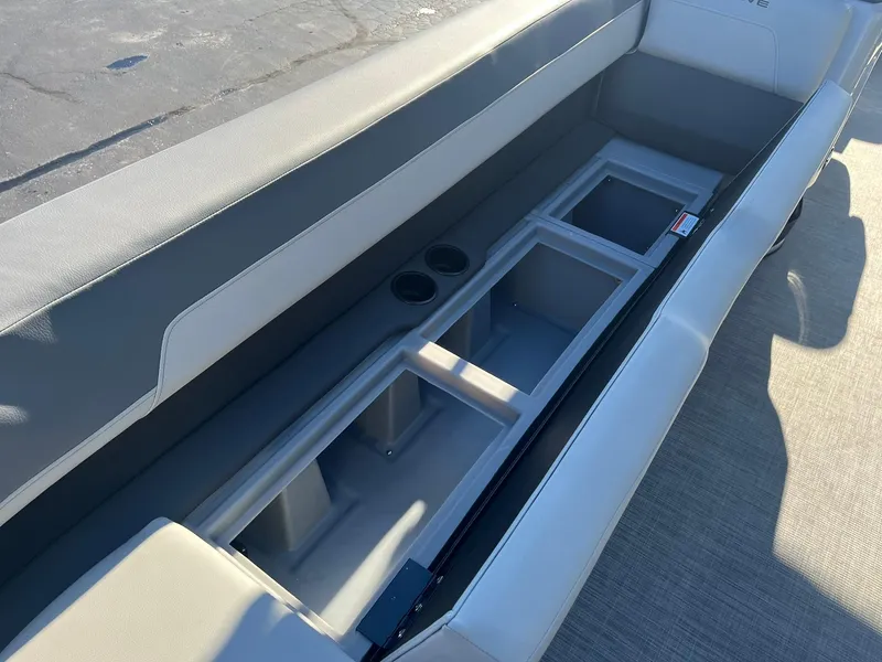 Slide: The Image of 2025 Lowe LS 230 WT boat interior with storage compartments and cup holders. - 24