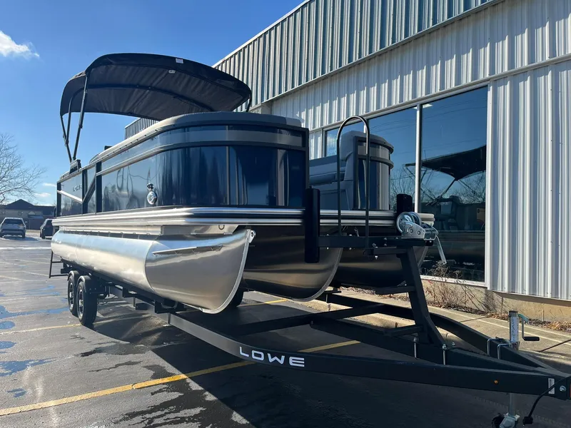 Slide: The Image of 2025 Lowe LS 230 WT pontoon boat on trailer outside a building. - 3