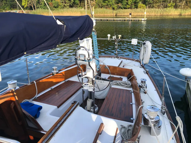 Slide: The Image of 1968 LeComte Northeast 38 sailboat with wooden deck, moored on calm water. - 12