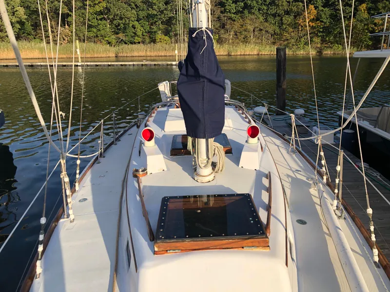 Slide: The Image of 1968 LeComte Northeast 38 sailboat docked, featuring a clean deck and covered mast. - 14