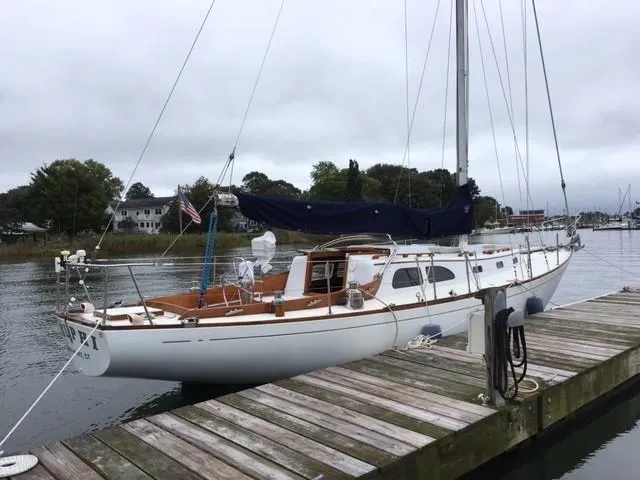 Slide: The Image of 1968 LeComte Northeast 38 sailboat docked at a marina on a cloudy day. - 2