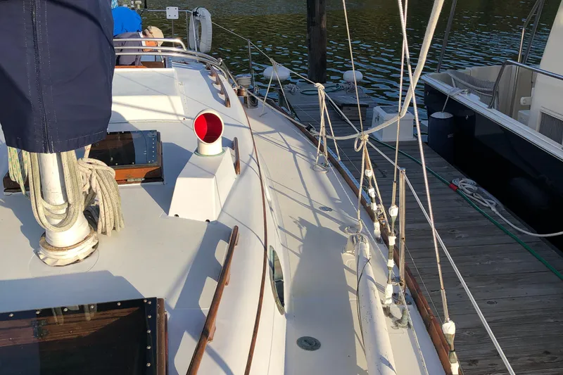 Slide: The Image of 1968 LeComte Northeast 38 sailboat deck, docked, with ropes and fittings visible. - 20