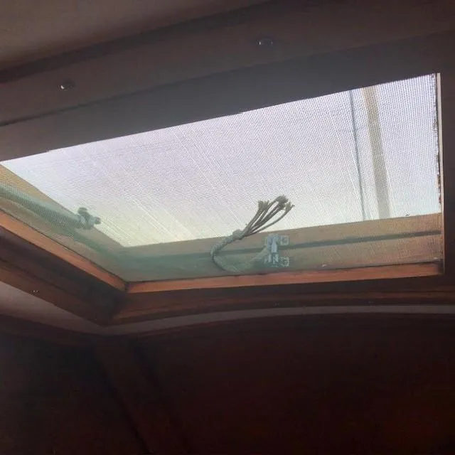 Slide: The Image of Interior view of a 1968 LeComte Northeast 38 sailboat hatch with a mesh screen. - 37