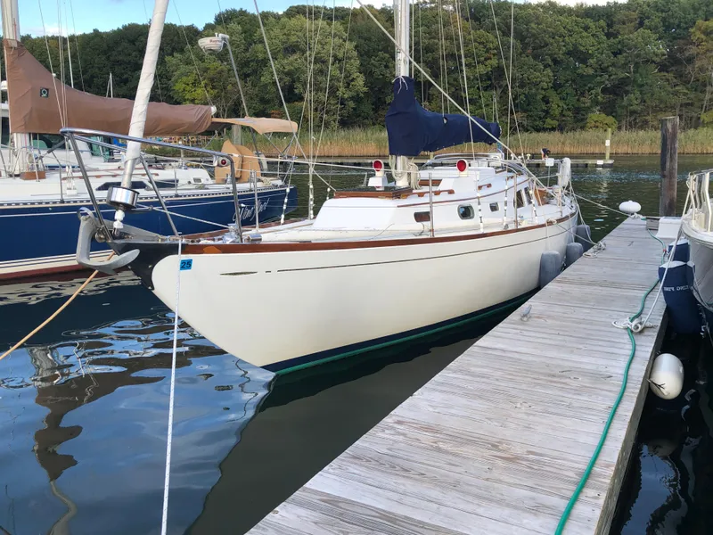 Slide: The Image of 1968 LeComte Northeast 38 sailboat docked at a marina, surrounded by calm water and trees. - 4