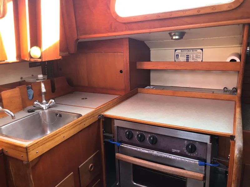 Slide: The Image of 1968 LeComte Northeast 38 yacht kitchen with wooden cabinetry and stainless steel sink. - 40