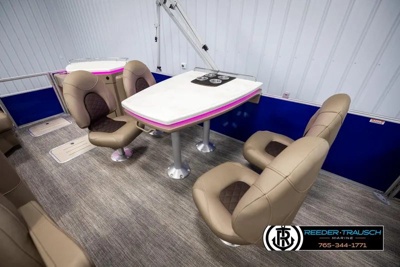 Slide: The Image of Interior of 2025 Bennington 23 SXPDSE pontoon boat with plush seating and table. - 23