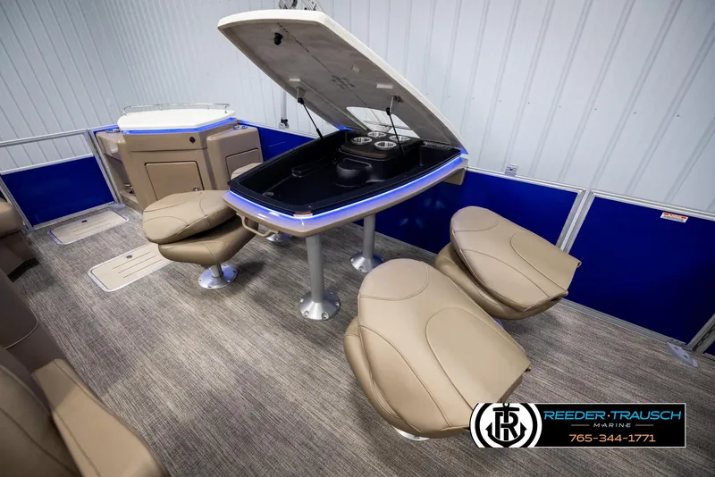 Slide: The Image of 2025 Bennington 23 SXPDSE boat interior with beige seating and blue accents. - 24