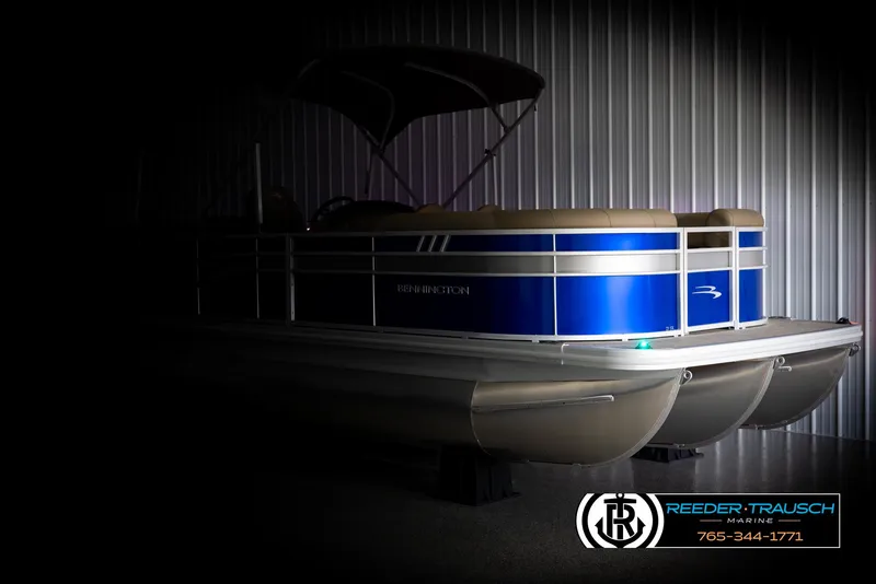 Slide: The Image of 2025 Bennington 23 SXPDSE pontoon boat in a dimly lit showroom. - 4