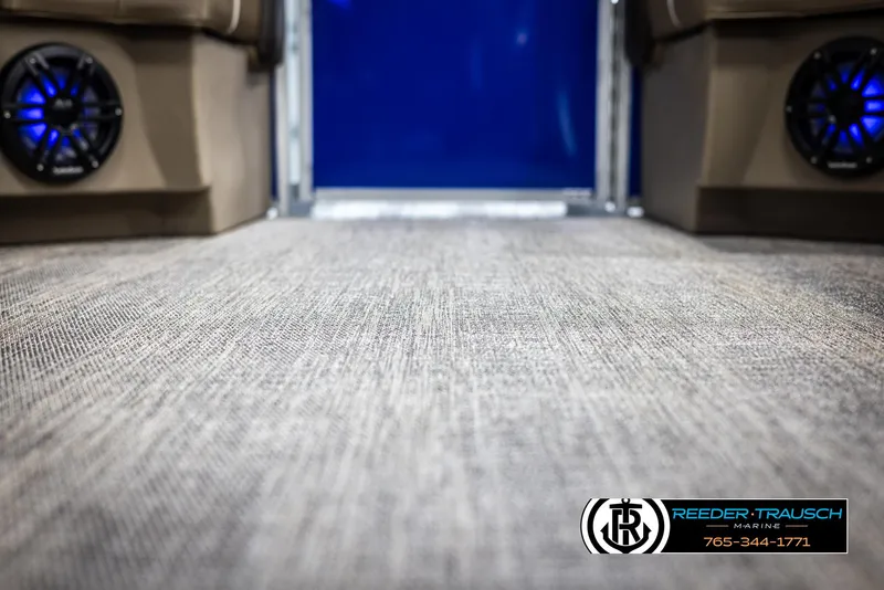 Slide: The Image of Interior of 2025 Bennington 23 SXPDSE boat with carpet flooring and blue-lit speakers. - 42