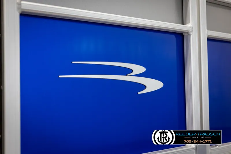 Slide: The Image of 2025 Bennington 23 SXPDSE boat logo on blue panel, Reeder-Trausch Marine branding. - 43