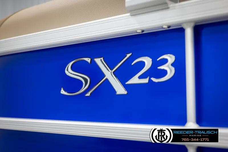 Slide: The Image of 2025 Bennington 23 SXPDSE boat, blue exterior with SX23 emblem, Reeder-Trausch Marine branding. - 46