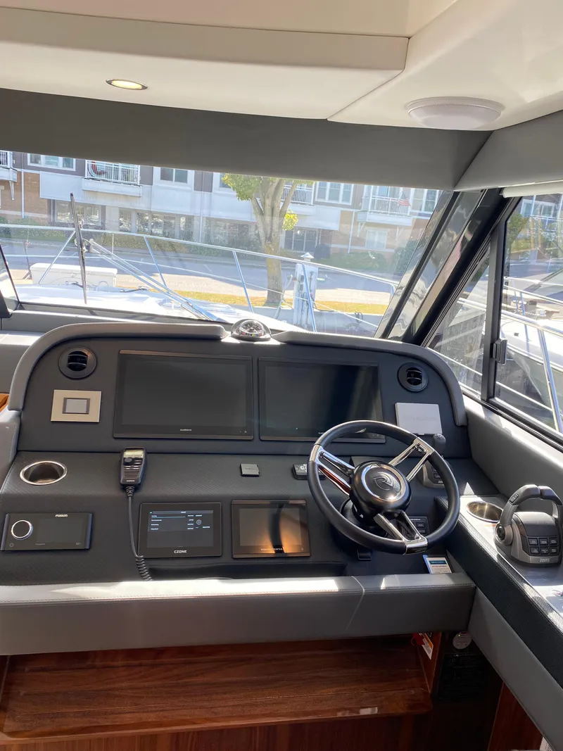 Slide: The Image of Interior helm of 2025 Riviera 465 SUV yacht with modern controls and steering wheel. - 22