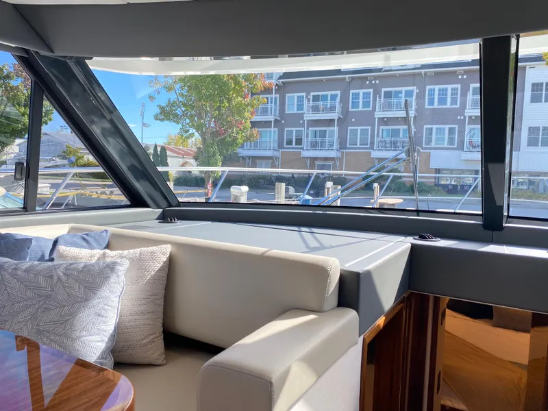Slide: The Image of Interior view of 2025 Riviera 465 SUV yacht with plush seating and marina backdrop. - 23