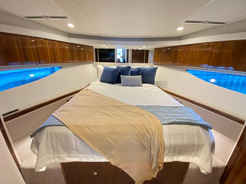 Slide: The Image of Luxurious bedroom interior of 2025 Riviera 465 SUV yacht with elegant bedding and wood accents. - 26
