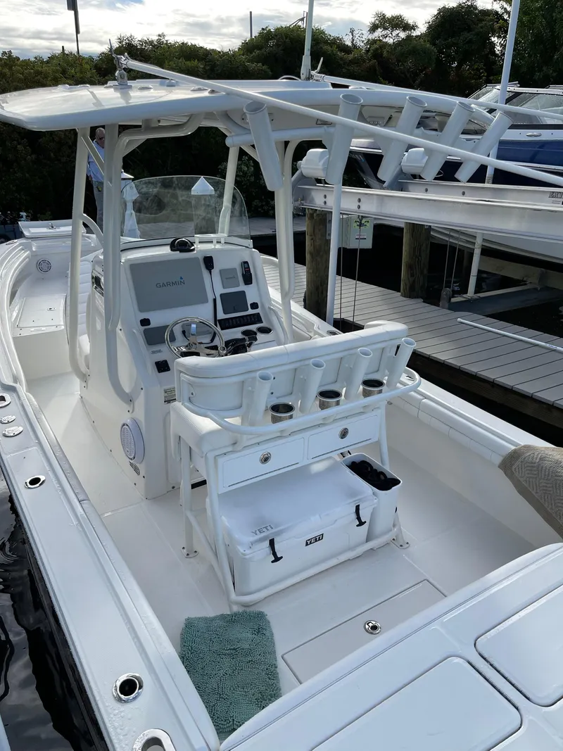 Slide: The Image of 2019 Regulator 23 FS boat interior with helm, seating, and fishing rod holders. - 10
