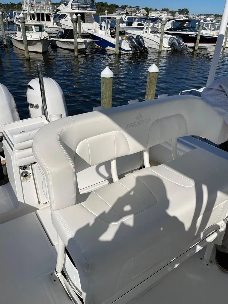 Slide: The Image of 2019 Regulator 23 FS boat interior with white seating at marina. - 14
