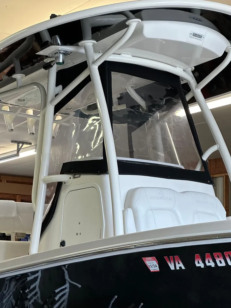 Slide: The Image of 2019 Regulator 23 FS boat with T-top and clear enclosure in a garage. - 22